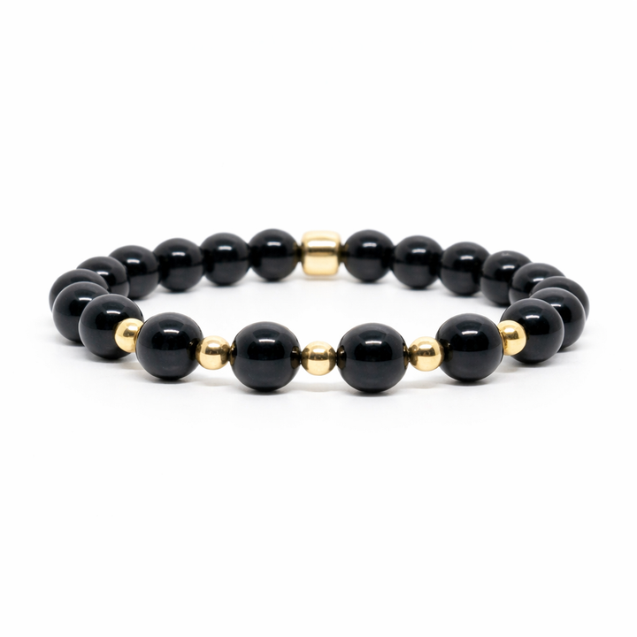 Black beaded bracelet with gold accents on a white background