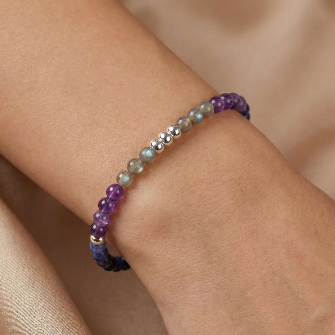 Multicolored beaded bracelet on a wrist against a neutral background