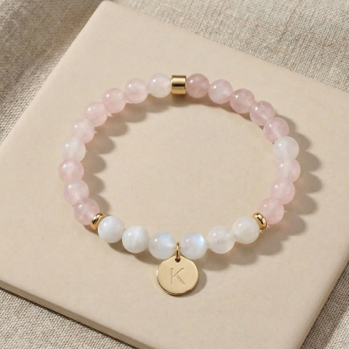 Beaded bracelet with a gold charm on a beige surface