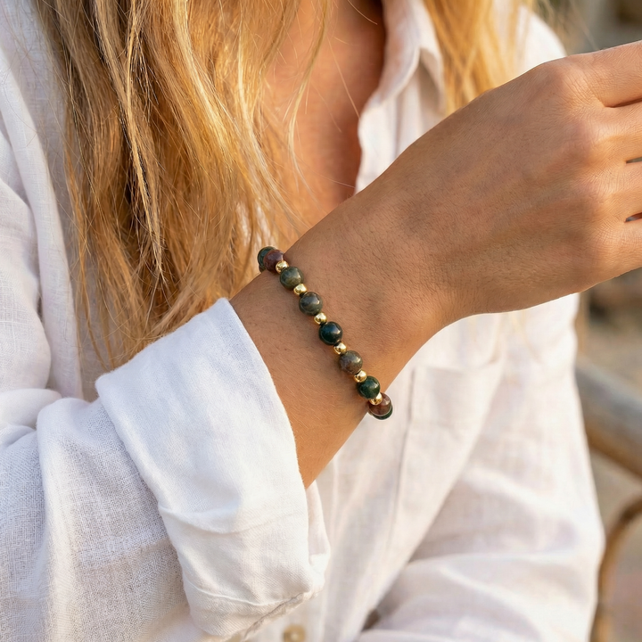 Close-up of a person wearing a beaded bracelet on a blurred natural background