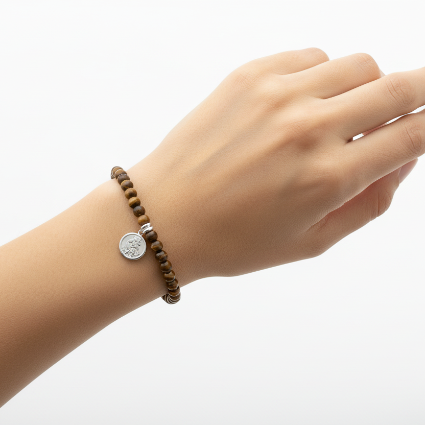 Tiger's Eye beaded bracelet with a silver charm on a white background